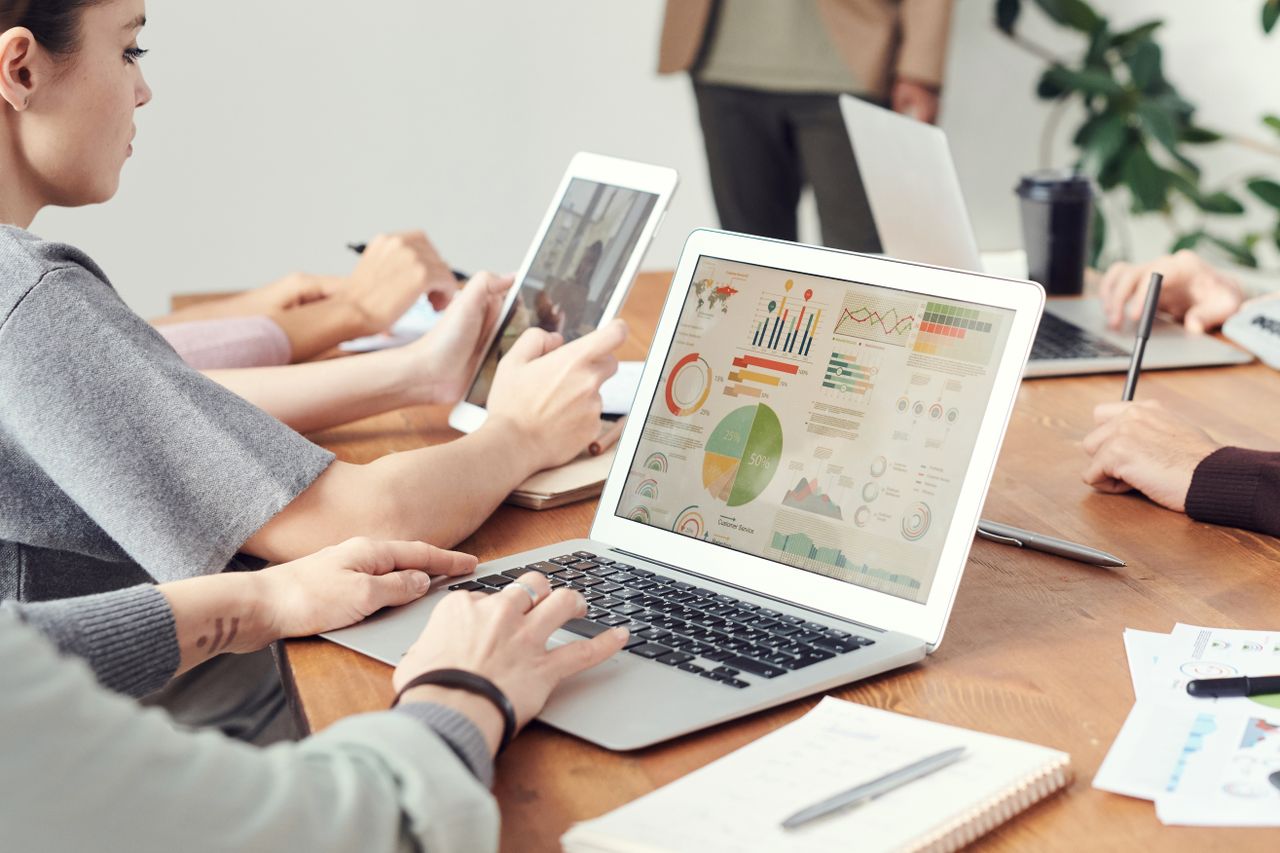 About Coworkers analyzing data charts on laptops during a team meeting.